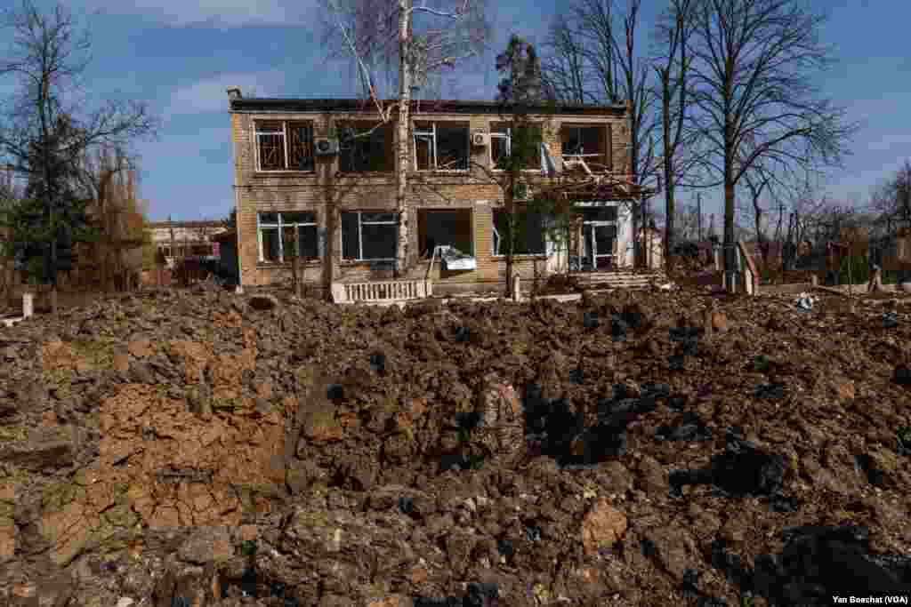 A soldier inspects a crater created by a 500kg bomb dropped by a Russian plane in the town of Ocheretyno, near Avdiivka, March 4, 2024.