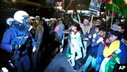 Protesters scuffle with riot police during a rally outside the Israeli Embassy in Athens, Greece, Oct. 18, 2023.