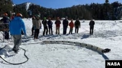 Team members from JPL test a snake robot called EELS at a ski resort in the Southern California mountains in February 2023. (Photo Credit: NASA/JPL-Caltech)