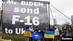 Beberapa demonstran mendesak Presiden AS Joe Biden untuk mengirim jet tempur F-16 ke Ukraina, saat aksi unjuk rasa di luar Hotel Marriott tempat Biden menginap selama kunjungannya ke Polandia 22 Februari 2023 lalu (foto: dok). 