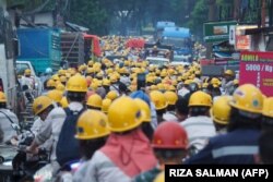 Karyawan perusahaan nikel PT Indonesia Morowali Industrial Park (IMIP) tampak bersiap akan pulang usai bekerja di Konawe, 14 April 2023. (Foto: RIZA SALMAN/AFP)