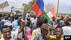 Supporters of Niger's coup leaders hold a Russian flag as they gather for a demonstration in Niamey on Aug. 11, 2023, near a French airbase in Niger. 