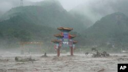 A traditional gate is inundated by flood waters in the Miaofengshan area on the outskirts of Beijing, Aug. 1, 2023. 