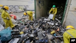 FILE - Workers sort through electronic waste collected from a Nairobi slum and brought in for recycling, at the East African Compliant Recycling facility in Machakos, near Nairobi, in Kenya, Aug. 18, 2014.