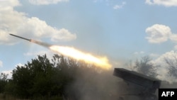 FILE - Ukrainian servicemen open fire on Russian positions with a Grad BM-21 multiple rocket launcher at the front line between Russian and Ukraine forces in the countryside of the eastern Ukrainian region of Donbas on July 19, 2022.