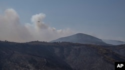 A helicopter operates near the Fyli suburb, northwest Athens, Aug. 25, 2023.