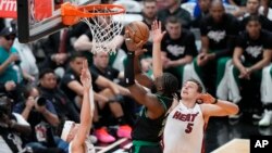 Košarkaš Bostona Džejlen Braun (u sredini) postiže koš preko Nikole Jovića iz Majamija (Foto: AP/Wilfredo Lee)
