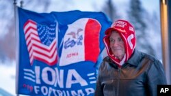 FILE - A man stands next to a flag that reads "Iowa for Trump" outside the the Machine Shed in Urbandale, Iowa, Jan. 11, 2024. 