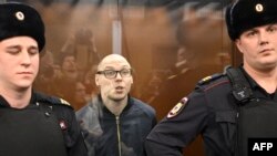 Artyom Kamardin aliyesimama (C) wakati akisomewa hukumu katika mahakama huko Moscow hapo Desemba 28, 2023.