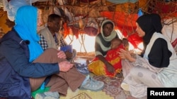 FILE - Cindy McCain, left, executive director of the U.N. World Food Program, meets an internally displaced Somali family at the Ladan camp for IDPs in Dollow, Somalia, May 1, 2023.