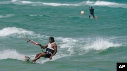 Kite surfers take advantage of gusty winds caused by the outer bands of Hurricane Idalia in North Miami Beach, Florida, Aug. 29, 2023.