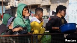 Palestinci čekaju u redu da dobiju humanitarnu pomoć u Rafi, 14. decembar 2023. (foto: Rojters/Saleh Salem)