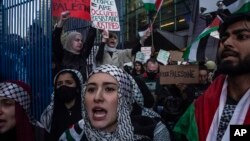 Palestinian supporters march with flags and signs and chant in protest as the Israel-Hamas war continues in the Middle East, Oct. 13, 2023, in New York.
