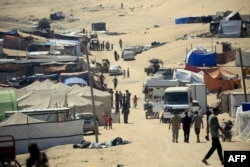Pengungsi Palestina berjalan di tengah tenda di Rafah di Jalur Gaza selatan, 31 Mei 2024. (Foto: AFP)