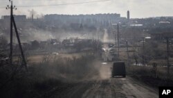 A Ukrainian police van drives on the highway for evacuation civilians in Khromove near Bakhmut, Ukraine, March 4, 2023.