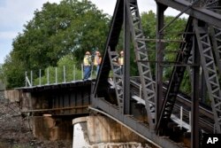 Emergency crews respond to the scene where several train cars are immersed in the Yellowstone River after a bridge collapse near Columbus, Mont., June 24, 2023.