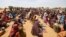 Sudanese refugees, who have fled the violence in their country, wait to receive food rations from World Food Program, near the border in Koufroun, Chad, May 9, 2023. 