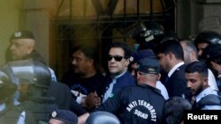 资料照片：2023年5月12日，安全人员在巴基斯坦伊斯兰堡护送前总理伊姆兰·汗（中）在伊斯兰堡高等法院出庭。（路透社照片）