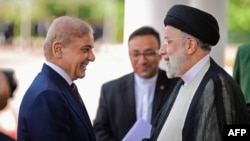 Presiden Iran Ebrahim Raisi (kanan) disambut oleh Perdana Menteri Pakistan Shehbaz Sharif setibanya di Islamabad pada 22 April 2024. (Foto: via AFP)
