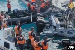 Personel Garda Pantai China tampak menggunakan senjata tajam dalam insiden di Second Thomas Shoal. (Foto: via AFP)