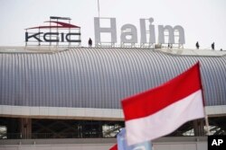 Para pekerja berdiri di puncak Stasiun Halim saat pembangunannya menjelang uji operasional kereta cepat Jakarta-Bandung pada September, di Jakarta, 12 Agustus 2023. (Foto: AP)