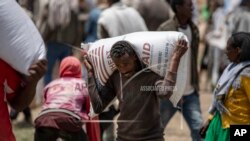 Mwanamume wa Kiethiopia akiwa amebeba gunia la ngano mabegani mwake na kuipeleka katika Shirika misaada la Tigray kwa ajili ya kusambazwa huko Agula, Mei 8, 2021. 