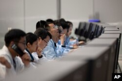 In this photo released by Xinhua News Agency, technical personnel work at the Beijing Aerospace Control Center (BACC) in Beijing, Sunday, June 2, 2024.(Jin Liwang/Xinhua via AP)