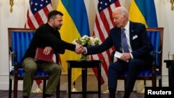 Presiden AS Joe Biden berjabat tangan dengan Presiden Ukraina Volodymyr Zelenskiy di Paris, Prancis, 7 Juni 2024. (Foto: REUTERS/Elizabeth Frantz)