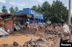 Residents salvage their household items after their homes were swamped following rains that triggered flooding and landslides in Rubavu district, Western province, Rwanda, May 3, 2023.