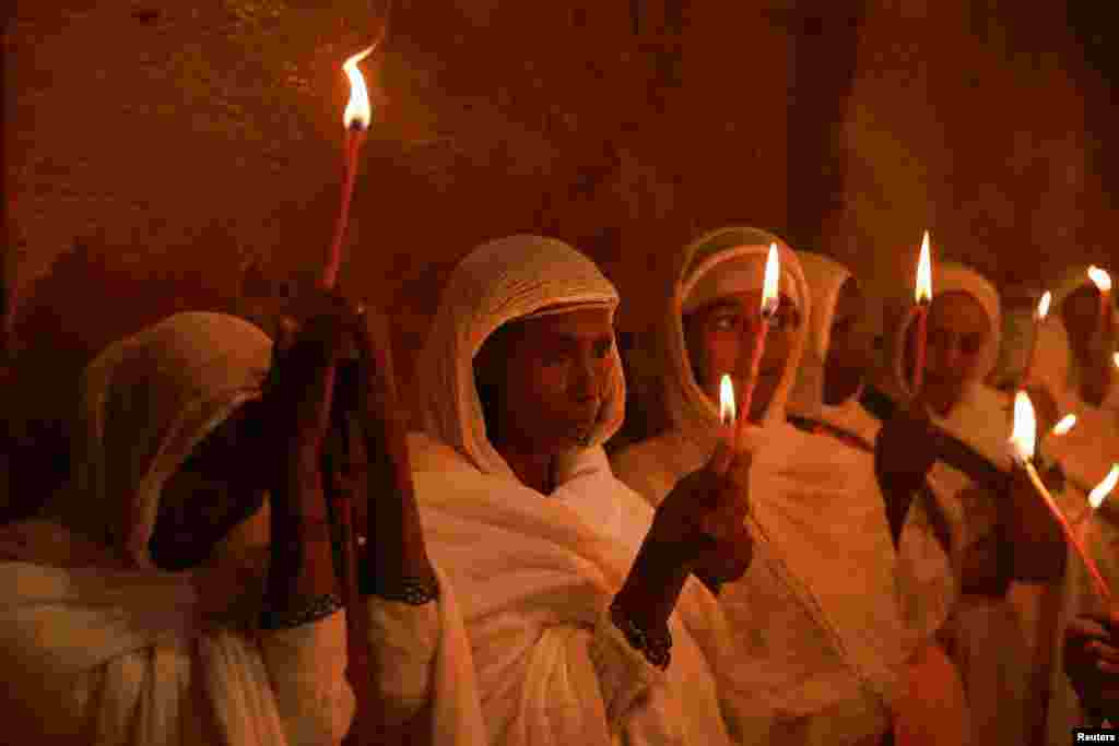 Ethiopian Orthodox faithful hold candles during the Easter Eve mass at the Wukro Cherkos rock-hewn church in Wukro, Tigray region, May 4, 2024. 