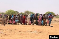 FILE - Sudanese refugees stand in line to receive food aid, in Koufroun, Chad, May 9, 2023.
