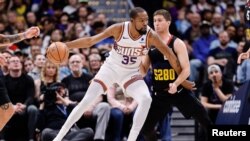 Kevin Durant (35) de Phoenix contrôle le ballon devant Collin Gillespie de Denver, USA le 27 mars 2024.
