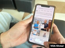 បុរសម្នាក់កំពុងមើលយុទ្ធនាការទាមទារឱ្យដោះលែង លោក កើត សារ៉ាយ នៅលើទូរស័ព្ទដៃ កាលពីថ្ងៃទី១១ ខែមេសា ឆ្នាំ២០២៤។ (លាស់ លីបលីប/វីអូអេ)