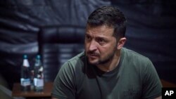 In this photo provided by the Ukrainian Presidential Press Office, Ukrainian President Volodymyr Zelenskyy listens to servicemen during his visit to the headquarters of brigades at the front line near Soledar, Donetsk region, Ukraine, Aug. 14, 2023. 