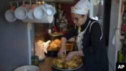 FILE - Majda Ould Ibbat prepares a traditional Morroccan chicken dish at home in Marseille, southern France, April 21, 2024.