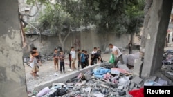 Palestinians inspect the site of an Israeli strike on a house in Rafah, in the southern Gaza Strip, April 25, 2024.