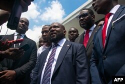 Smith Augustin, center, a member of the new transitional council, speaks to the press after the swearing in of the council in Port-au-Prince, Haiti, April 25, 2024.