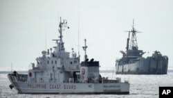 Philippine coast guard patrol vessel BRP Malapascua, left, goes near the Philippine navy ship BRP Sierra Madre at the Second Thomas Shoal, at the South China Sea, April 23, 2023.