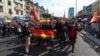 FILE - Protesters from the LGBTQ community hold rainbow flags as they march in Yangon, Myanmar, Feb. 8, 2021.