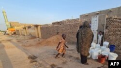 People queue to fill up on water in the capital Khartoum on June 24, 2023.