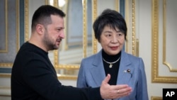 In this photo provided by the Ukrainian Presidential Press Office, Ukrainian President Volodymyr Zelenskyy, left, greets Japan's Foreign Minister Yoko Kamikawa in Kyiv, Ukraine, Jan. 7, 2024. 