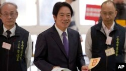 Kandidat presiden dari Partai Progresif Demokratik Lai Ching-te, tengah, yang juga dipanggil William, di tempat pemungutan suara di Kota Tainan, Taiwan selatan, 13 Januari 2024. (Foto: AP)