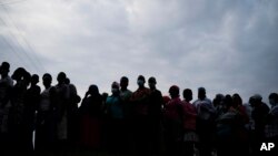 FILE - Ugandans wait to cast their votes for the presidential election in Kampala on Jan. 14, 2021.