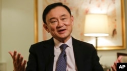 FILE - Thailand's former Prime Minister Thaksin Shinawatra responds to questions during a news interview in New York, March 9, 2016. 