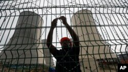 A man fixes a barbed wire on the fence of the Rooppur Nuclear Power Plant at Ishwardi in Pabna, Bangladesh, Oct. 4, 2023. 
