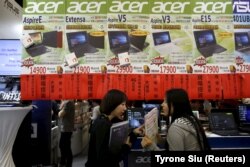 Seorang karyawan (kanan) memperkenalkan komputer laptop Acer kepada pelanggan selama acara Spring Computer di Taipei, Taiwan, 15 April 2016. (Foto: REUTERS/Tyrone Siu)