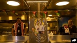 Pedagang kaki lima Yordania menghiasi van mereka dengan poster Putra Mahkota Yordania Hussein dan tunangannya, arsitek Saudi Rajwa Alseif, saat konser di sebuah stadion olahraga di Amman, Yordania, Senin, 29 Mei 2023. (AP/Nasser Nasser)