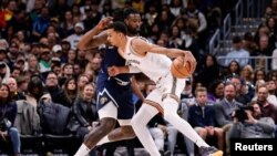 Victor Wembanyama (1) de San Antonio contrôle le ballon face au centre de Denver, USA, le 26 novembre 2023.