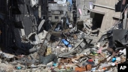 A Palestinian walks through the destruction left by the Israeli offensive on Khan Younis, Gaza Strip, March 8, 2024.
