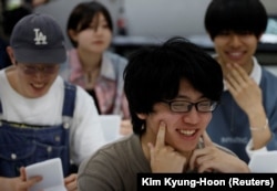 Para siswa berlatih tersenyum pada kursus pelatihan senyum di Sekolah Seni Sokei di Tokyo, Jepang, 30 Mei 2023. (Foto: REUTERS/Kim Kyung-Hoon)